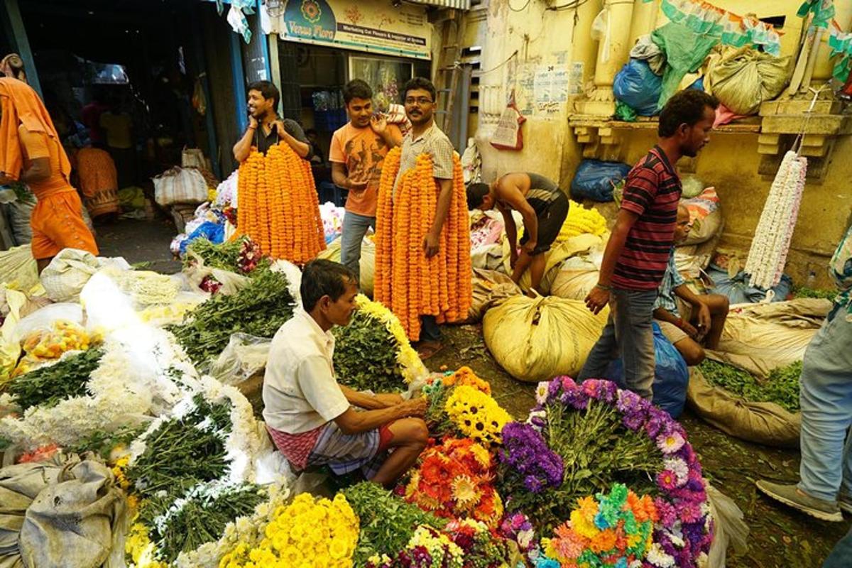 a group of people standing around a market with flowers