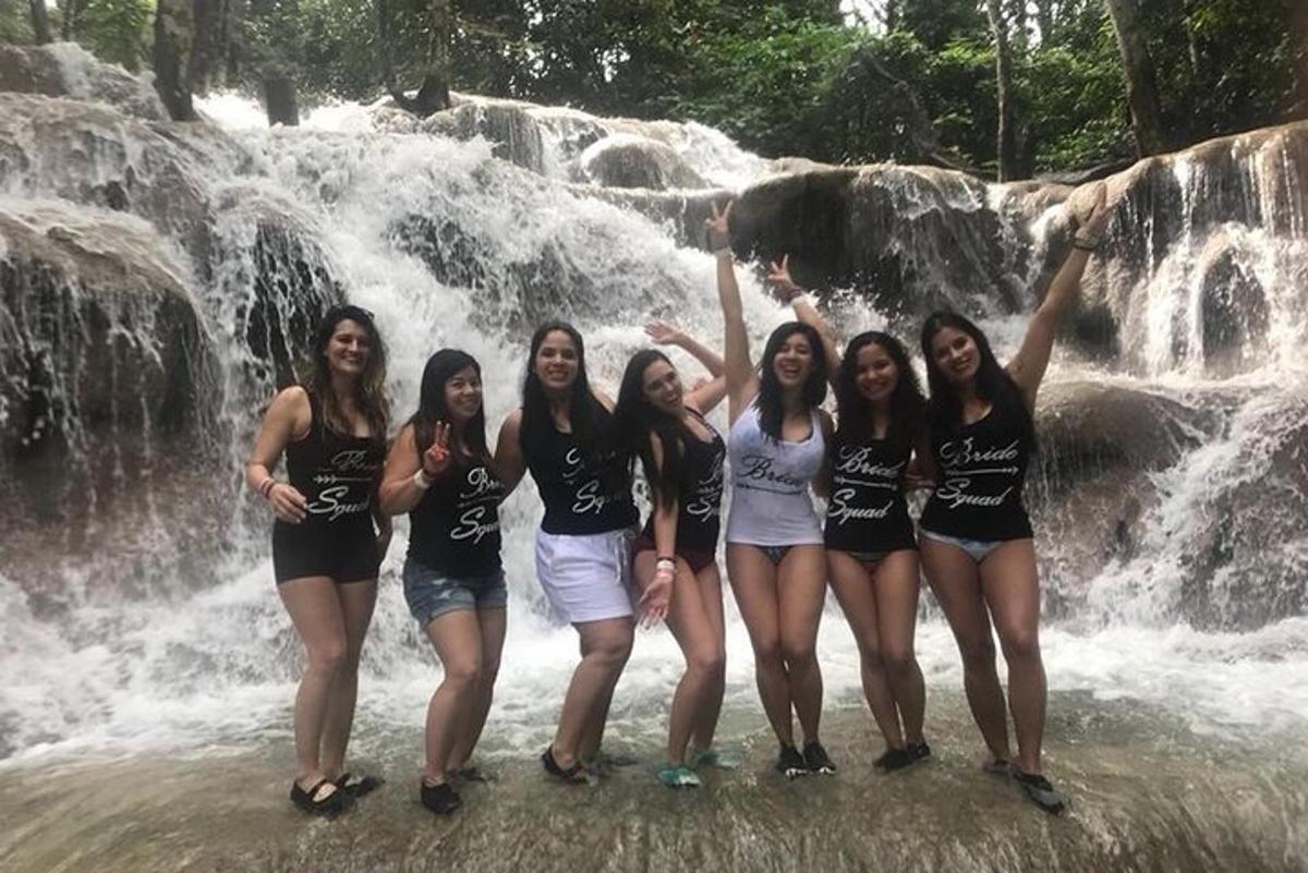 sekelompok wanita berdiri di depan air terjun