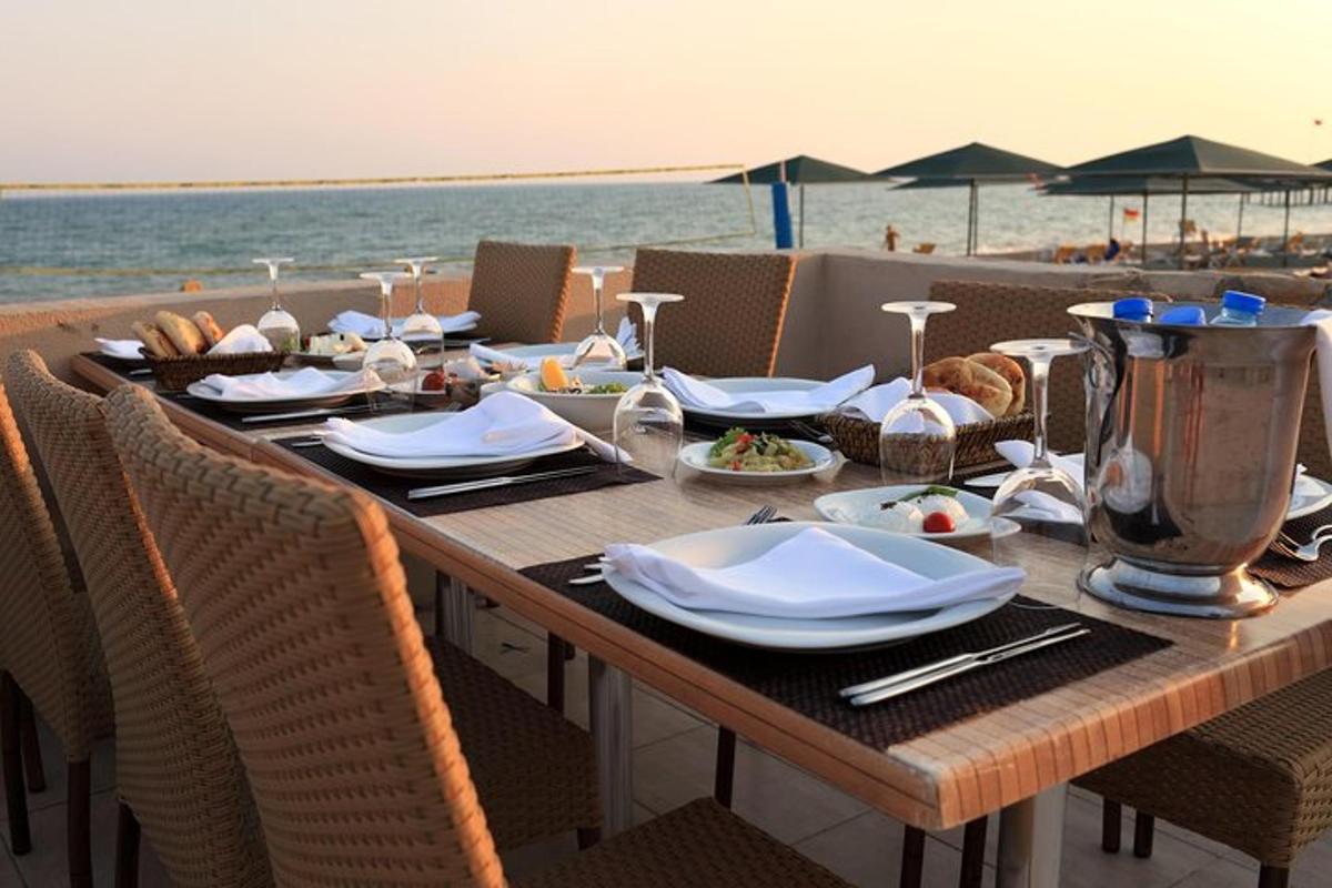 una taula de fusta amb plats de menjar a la platja