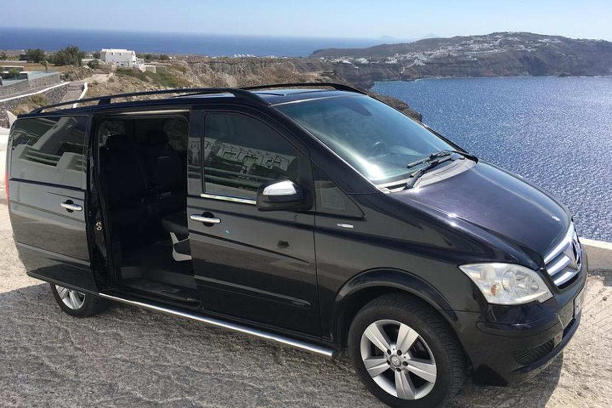 črn kombi parkiran ob vodni površini