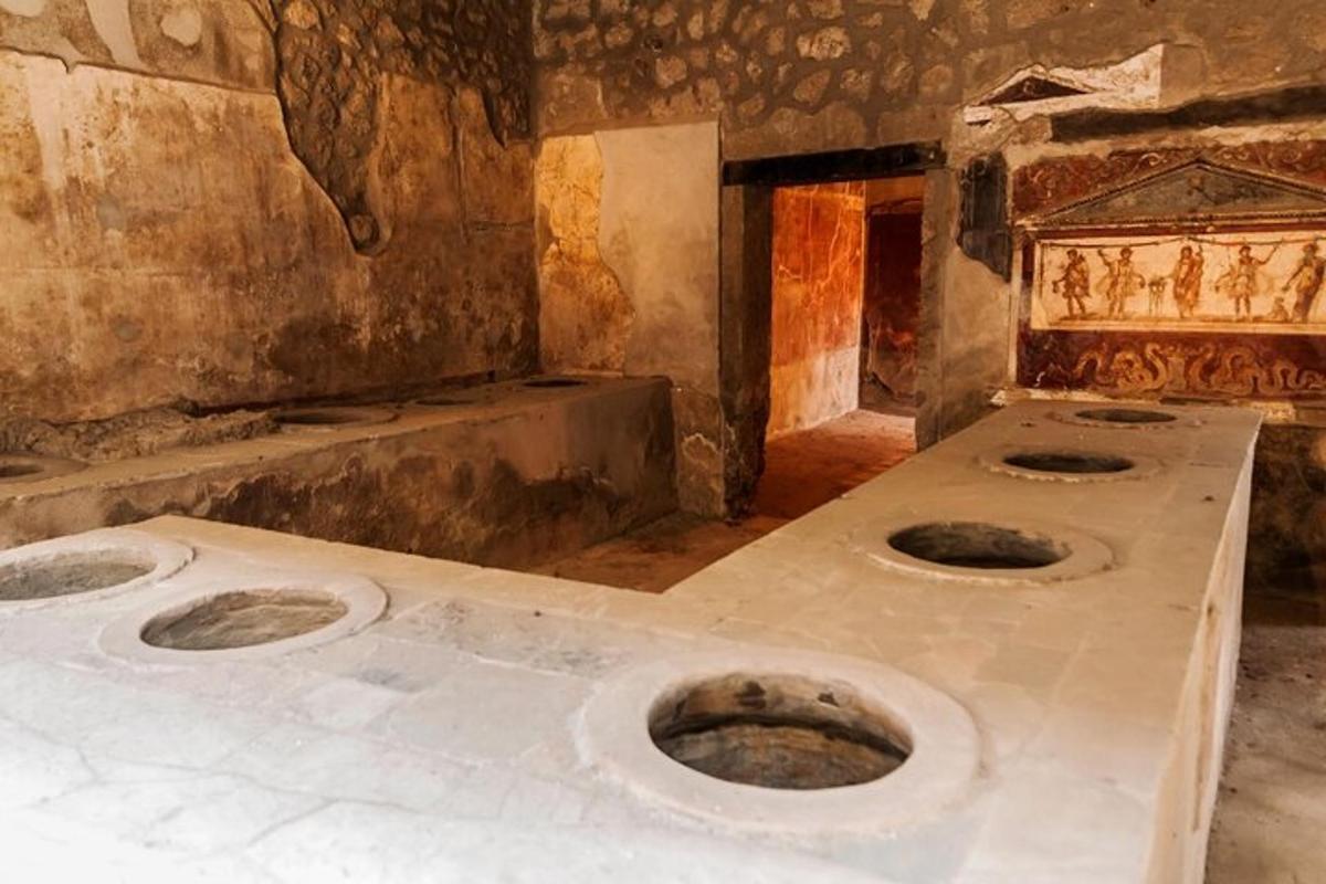 a dirty room with three toilets in the floor