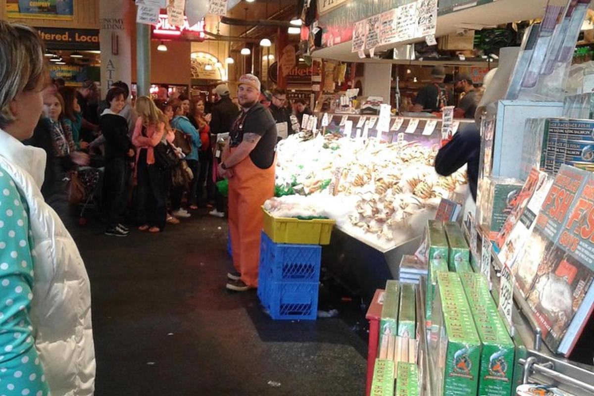 un gruppo di persone in piedi intorno a un mercato con del cibo