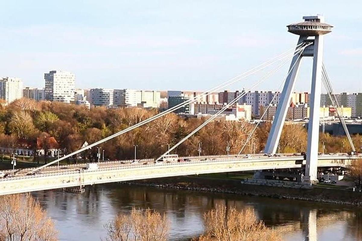 a bridge over a river with a city in the background