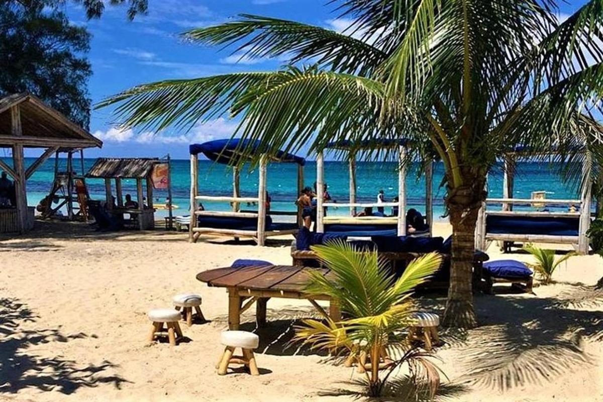 a beach with a wooden table and a palm tree