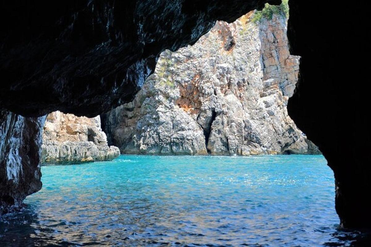 uma caverna com uma piscina de água azul e pedras