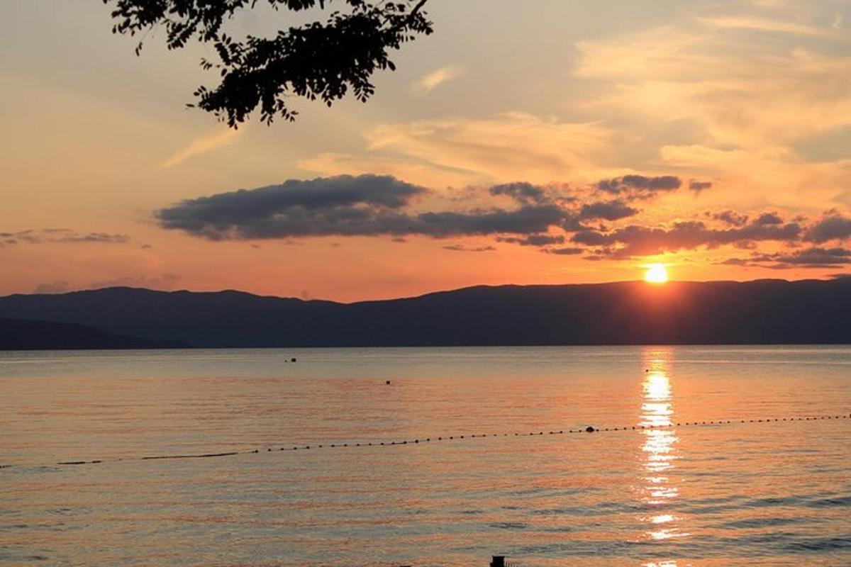 un tramonto sull'acqua con un gruppo di uccelli