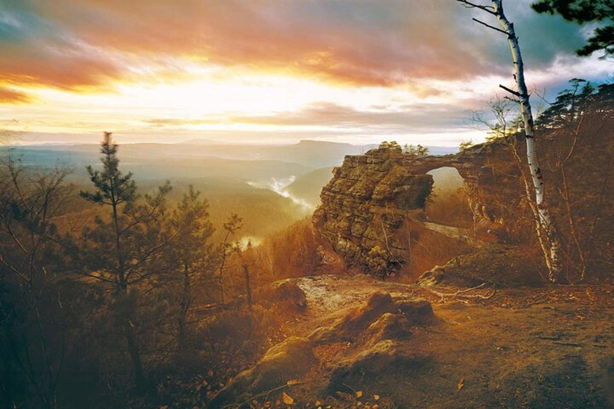 et maleri af et bjergudsigt med solnedgang