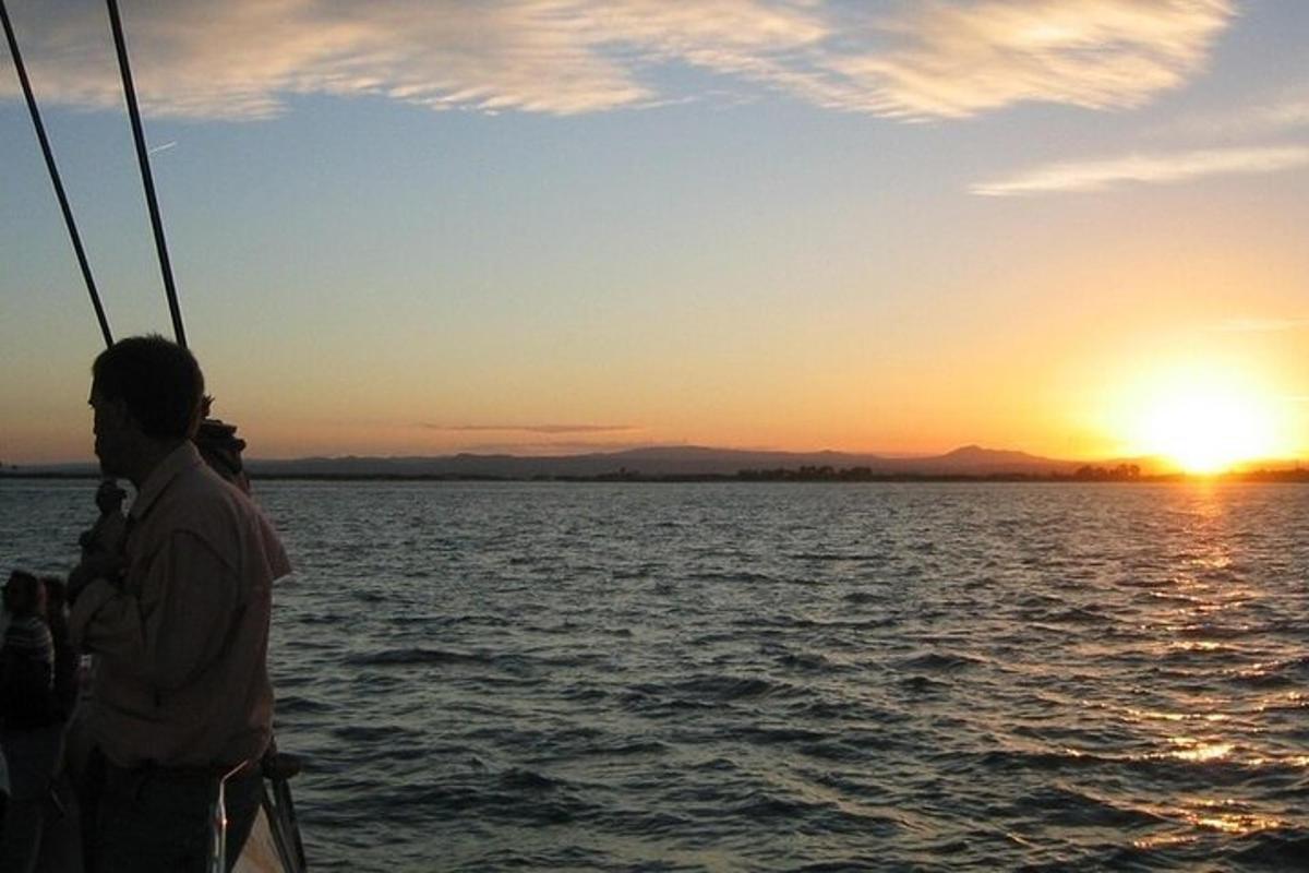 a man and a woman on a boat at sunset