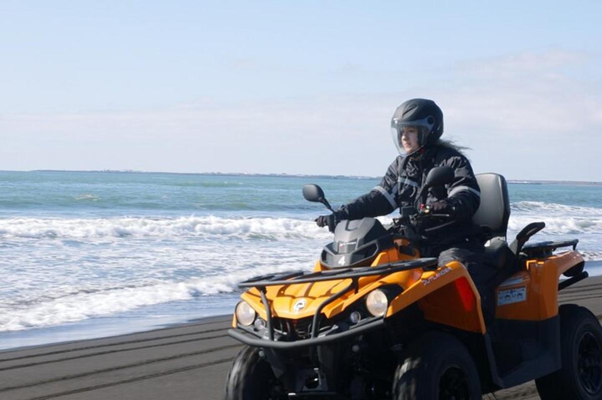 uma pessoa andando de quadriciclo na praia