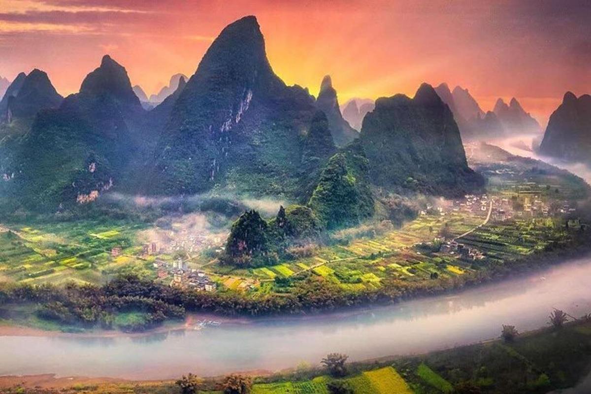 an island in a river in front of mountains