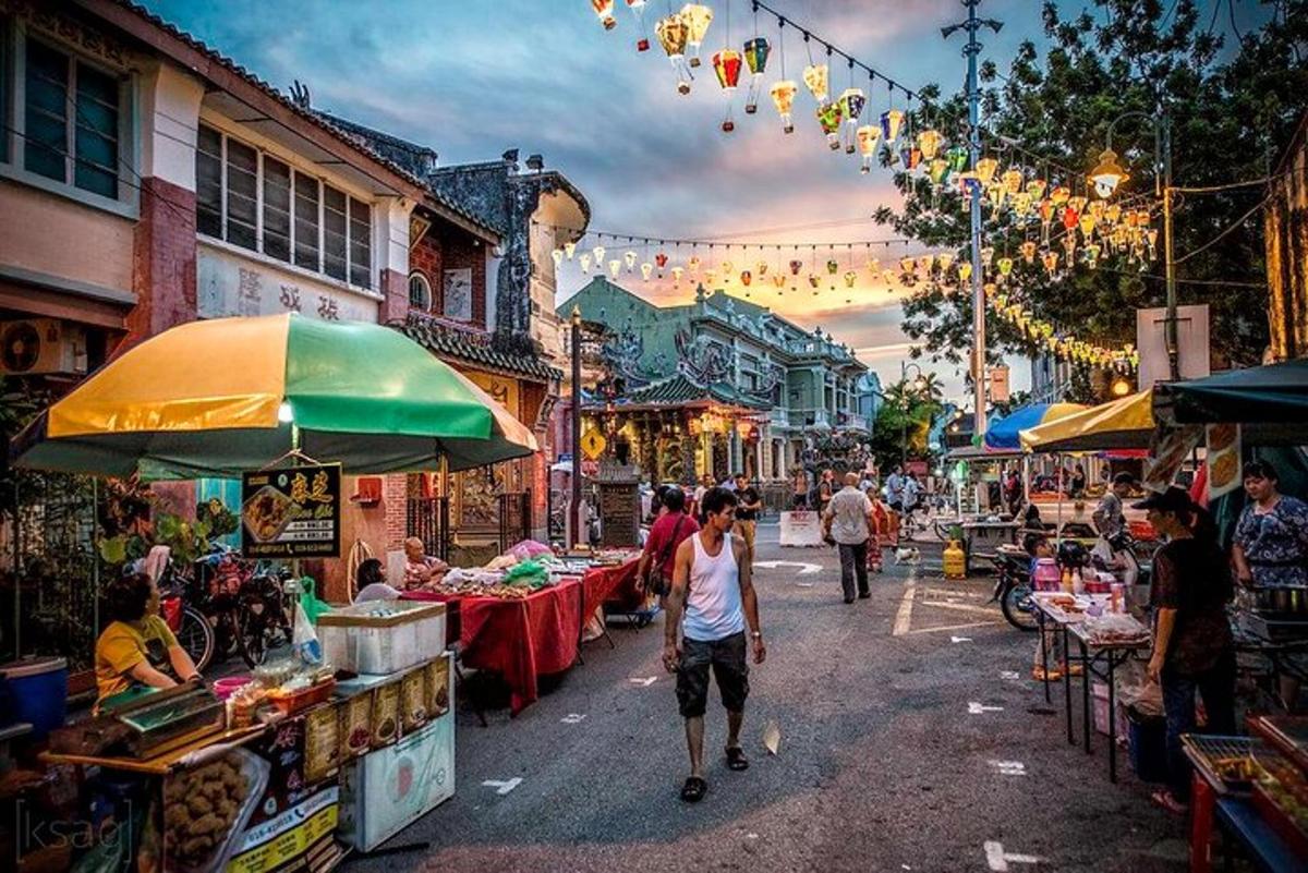a woman walking down a street in an outdoor market