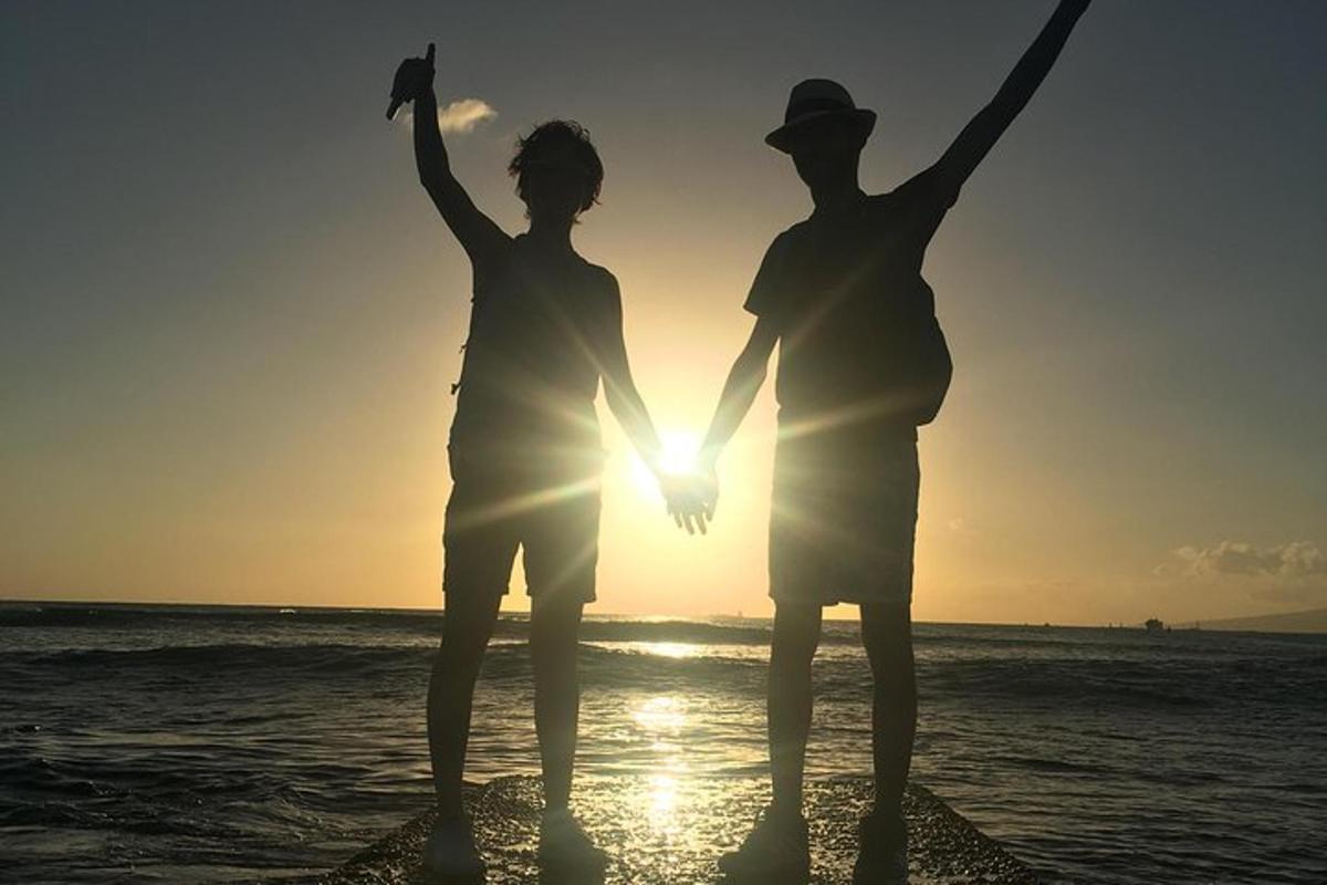 due persone in piedi sulla spiaggia al tramonto