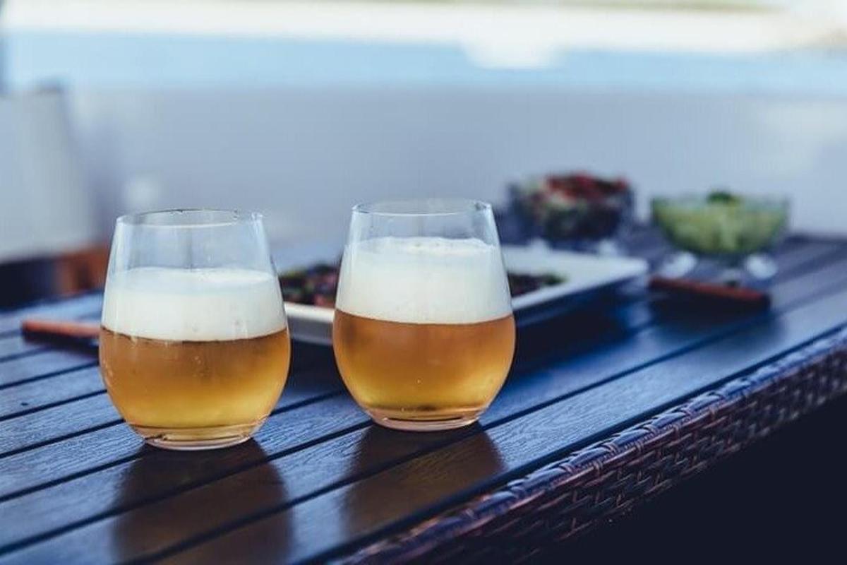 due bicchieri di birra appoggiati su un tavolo di legno