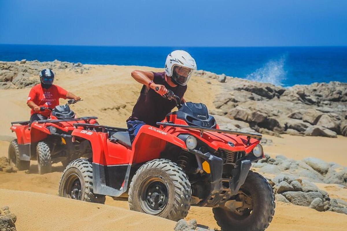 dues persones que condueixen quads al desert