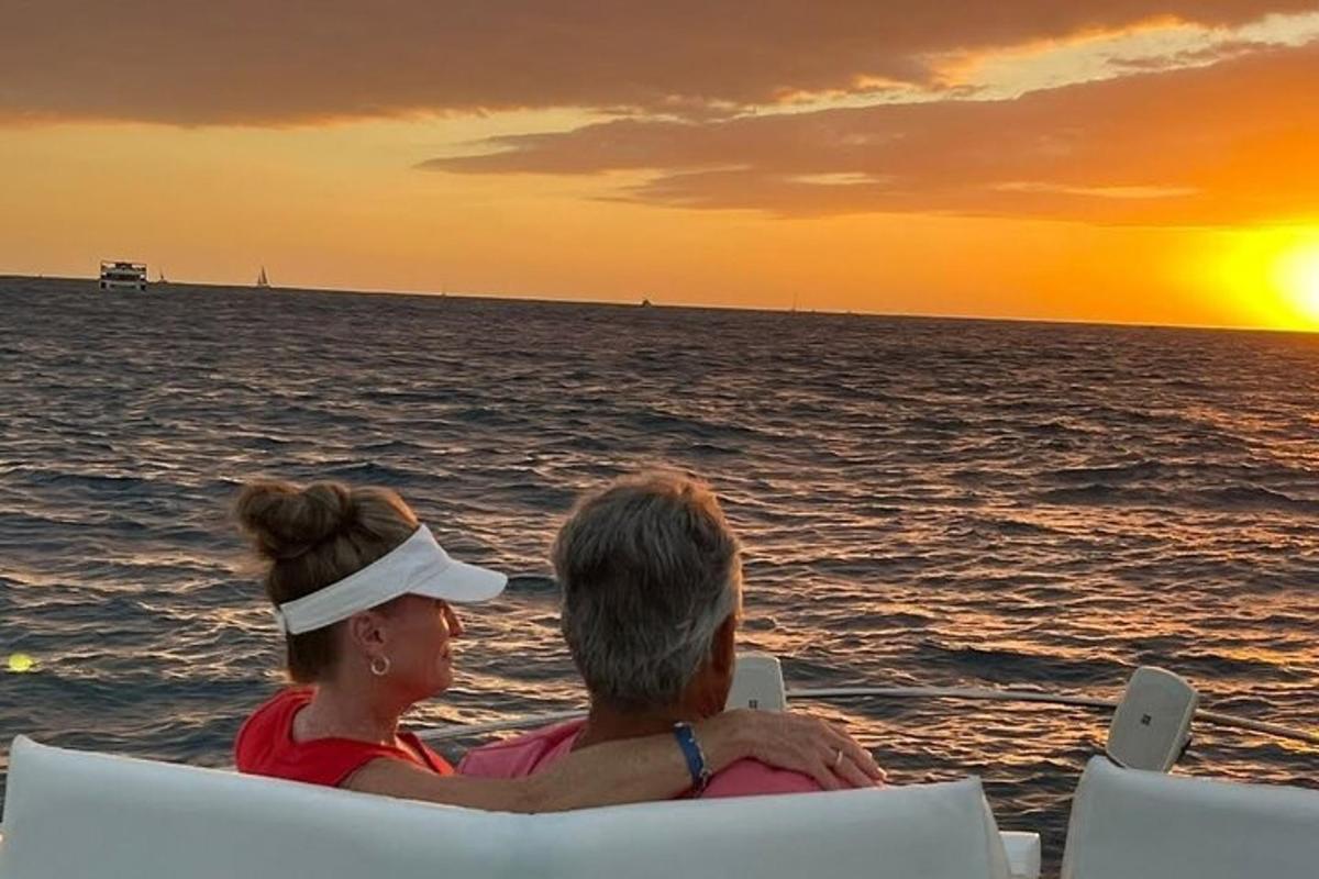 a man and a woman sitting in chairs watching the sunset