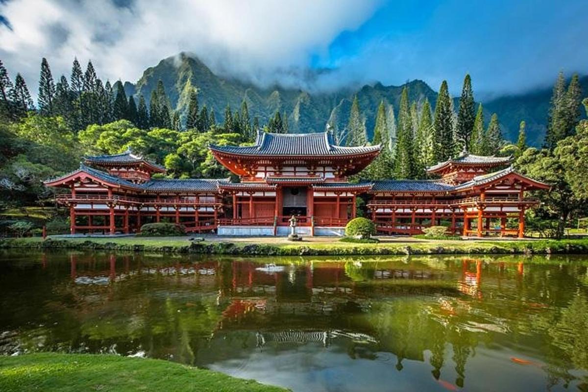 a building with a pond in front of a mountain