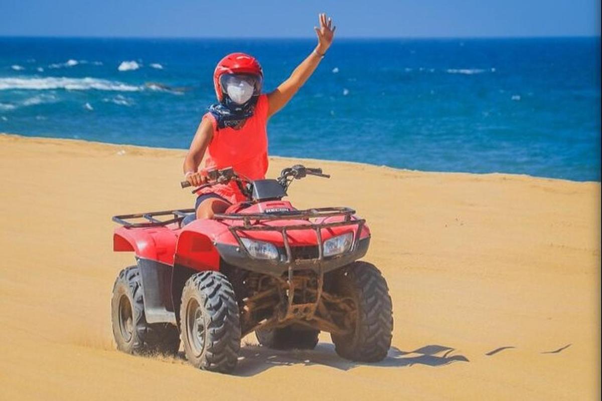 oseba, ki se vozi s štirikolesnikom po plaži