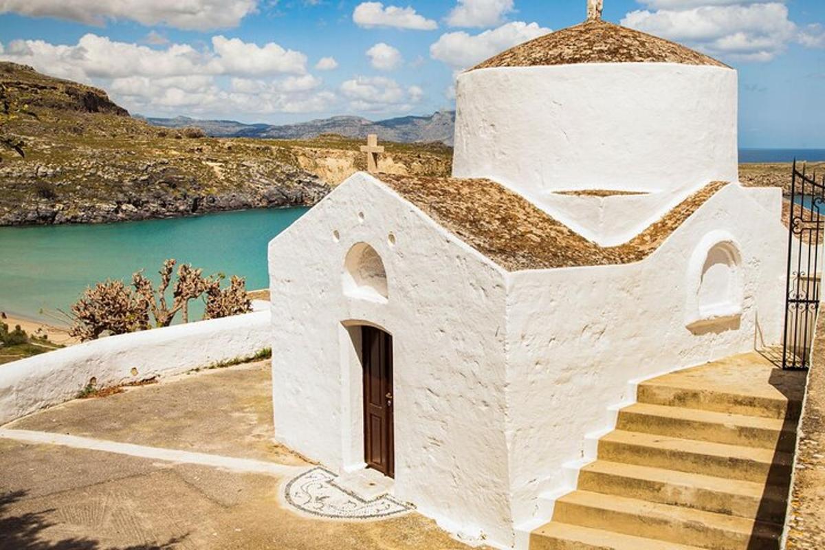 una església blanca amb escales al costat d'una massa d'aigua