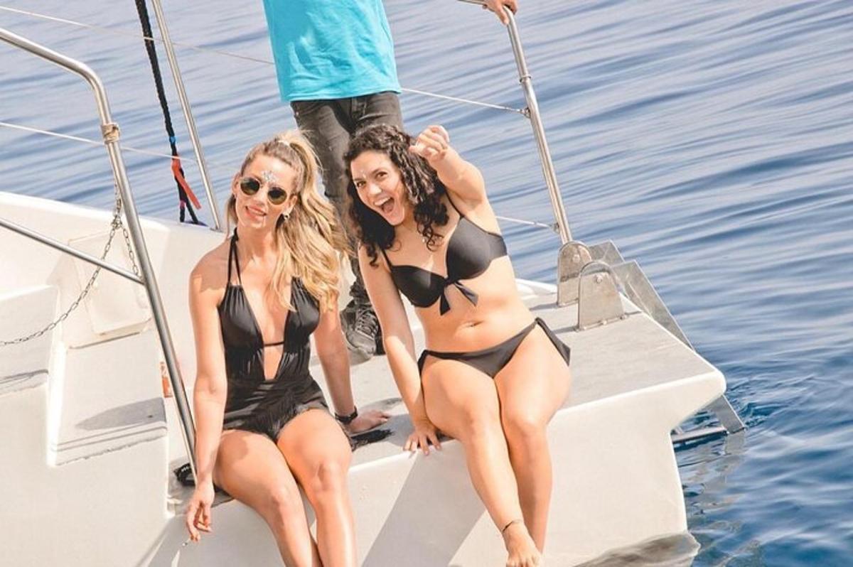 two women in bikinis sitting on a boat