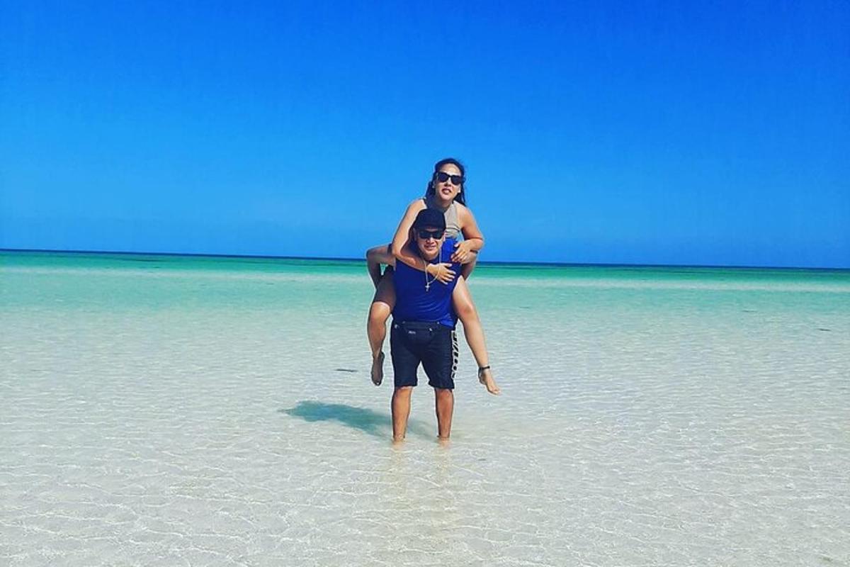 en mand og en kvinde står i vandet på en strand