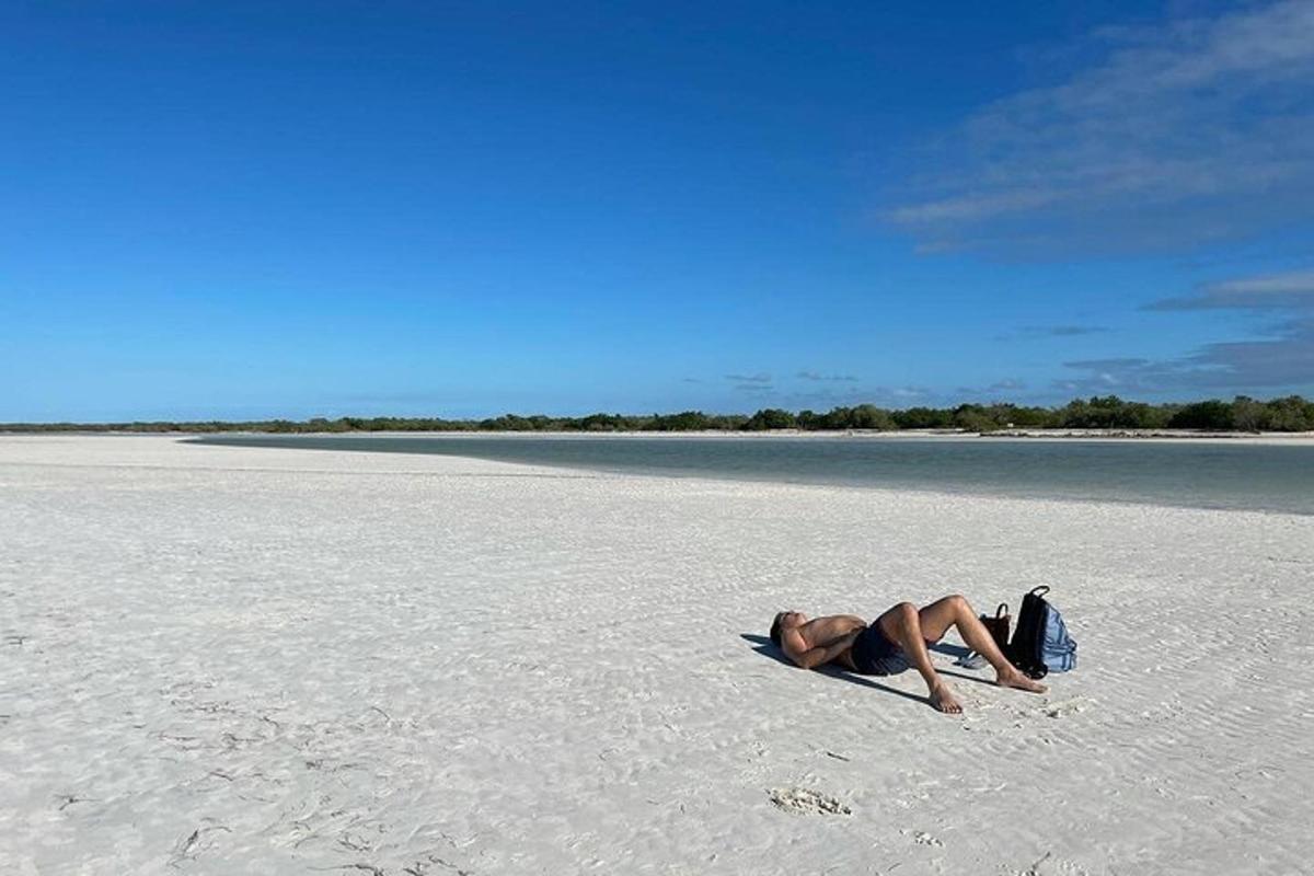 en mand liggende på sandet på en strand