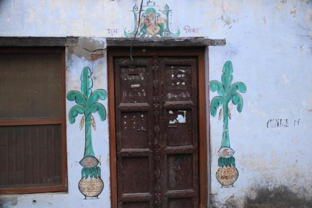 una porta amb arbres pintats al costat d'un edifici