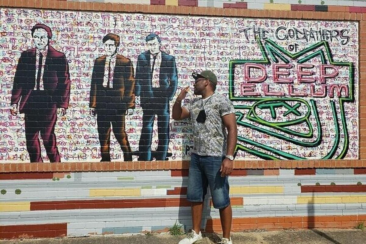 a man standing in front of a wall with a mural