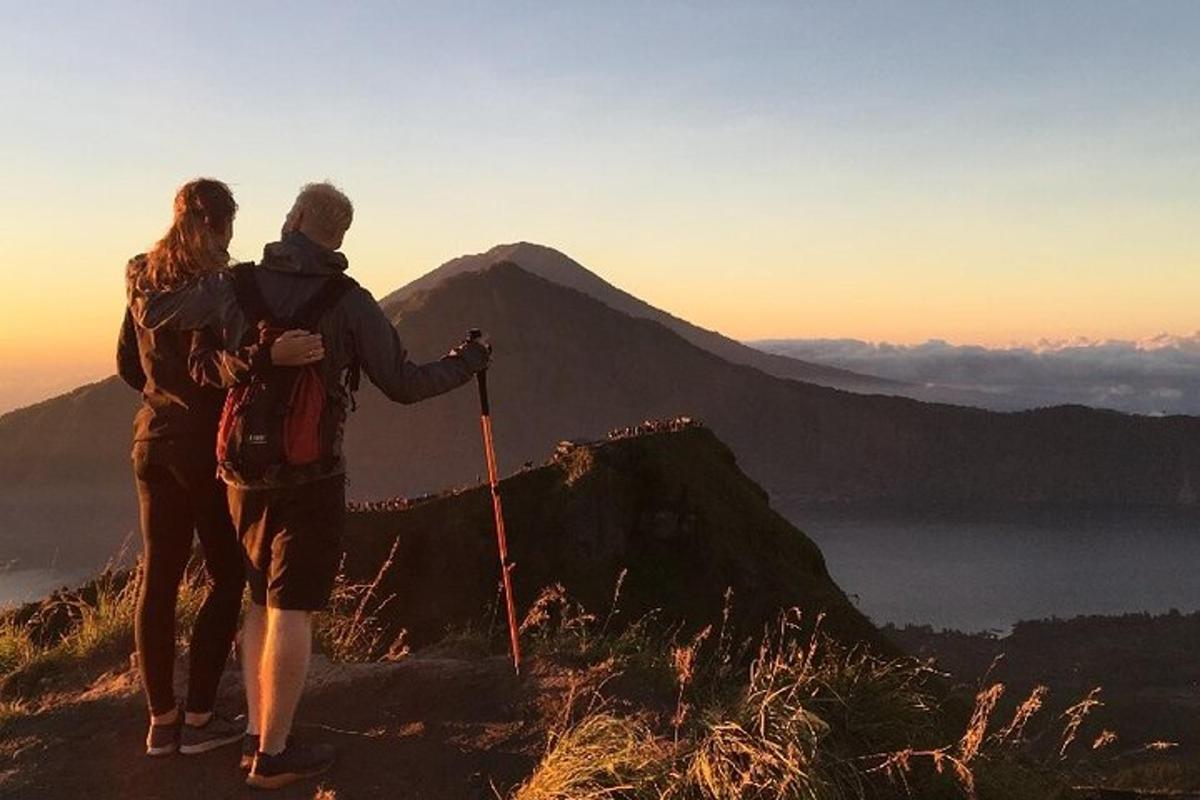 un uomo e una donna in piedi sulla cima di una montagna