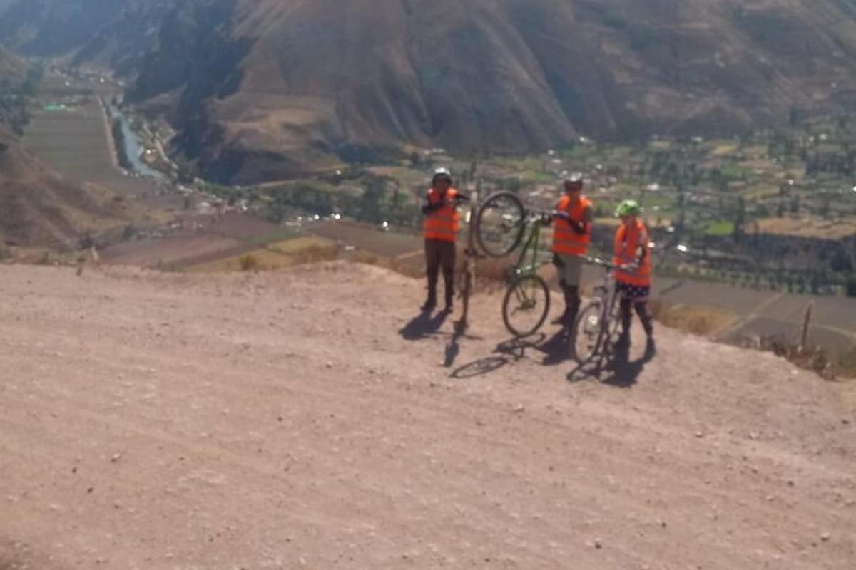 Un grupo de tres personas con sus bicicletas en una montaña.