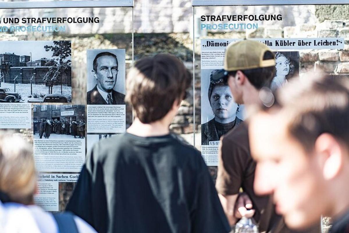 eine Gruppe von Menschen betrachtet eine Ausstellung mit Fotografien