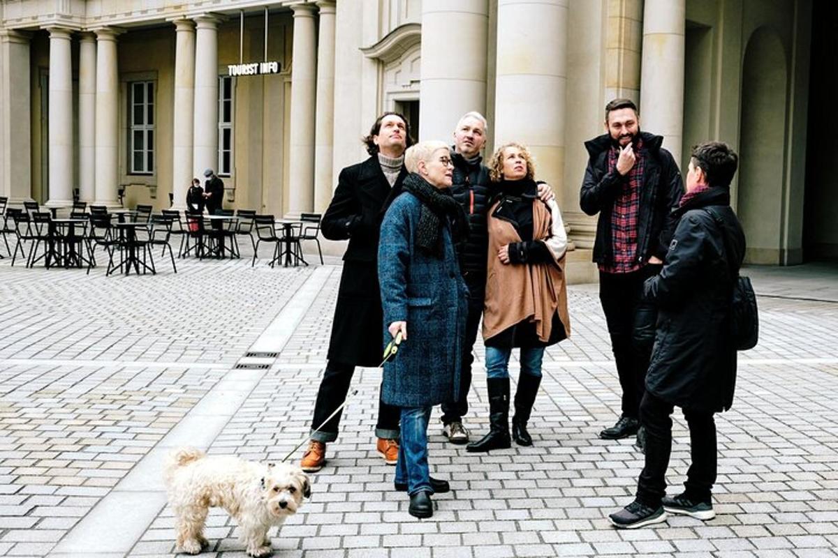un gruppo di persone in piedi davanti a un edificio con un cane