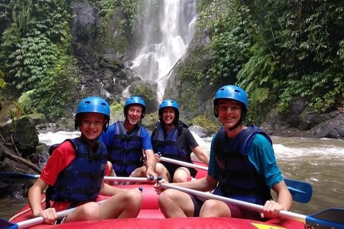 a group of people on a raft in front of a waterfall