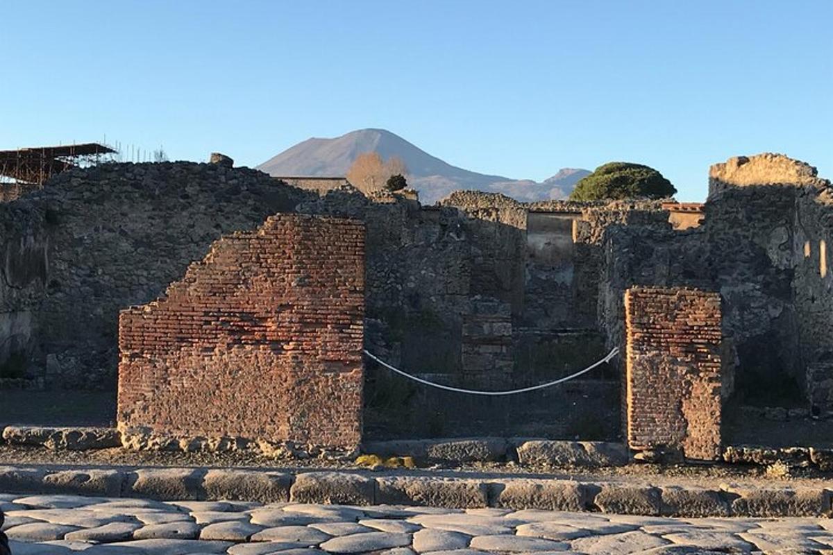Un viejo edificio de ladrillo con una montaña al fondo.