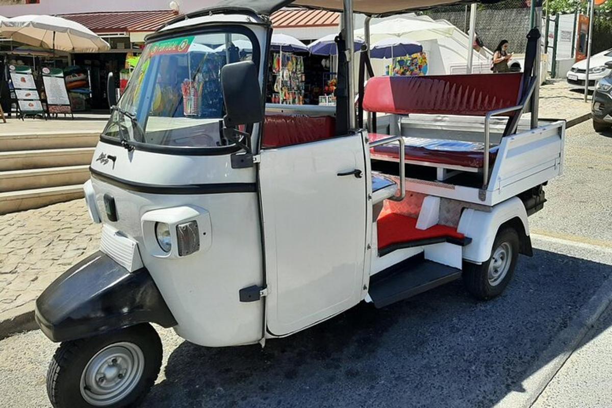 pieni golfkärry, jossa on punaiset istuimet kadulla