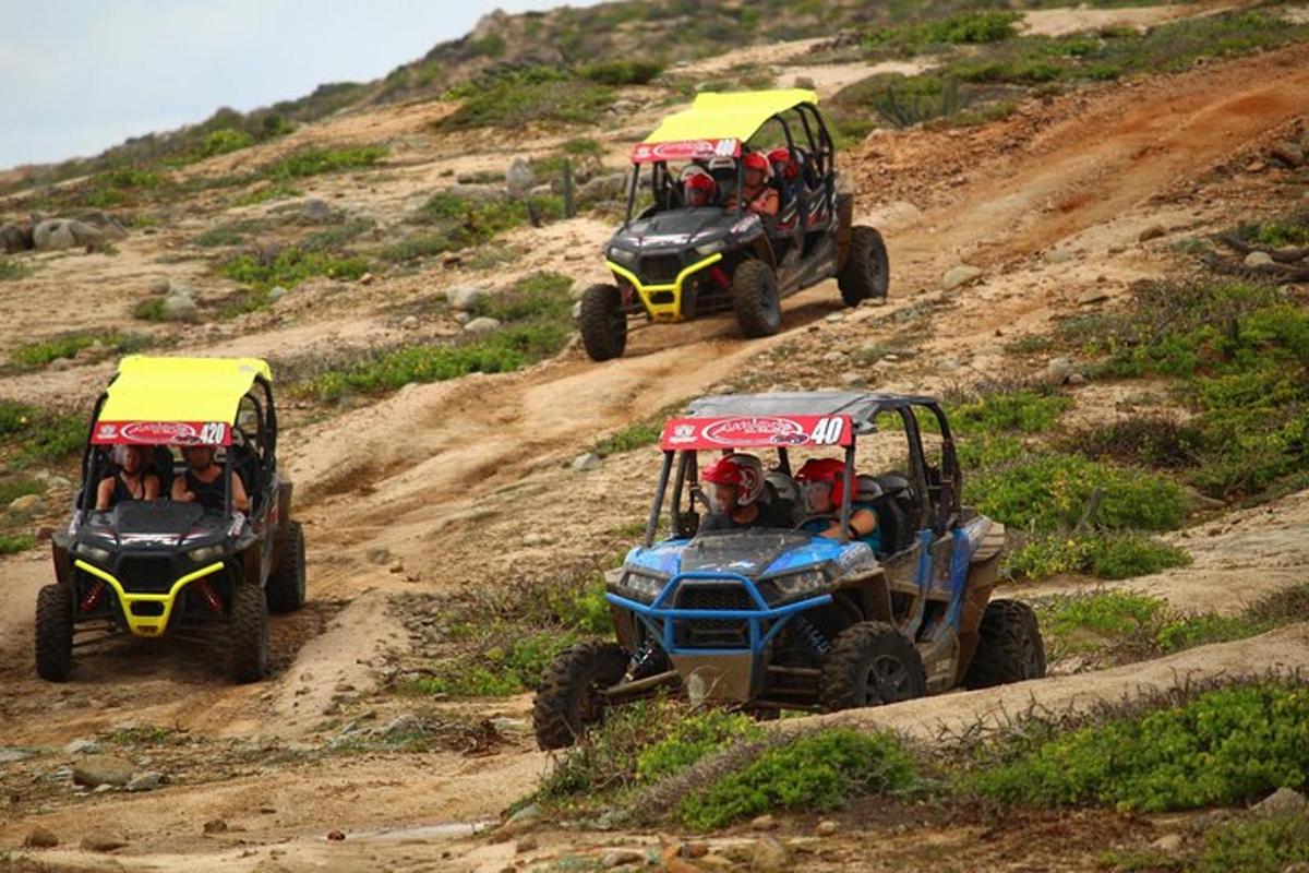 due quad che scendono da una collina sterrata con delle persone
