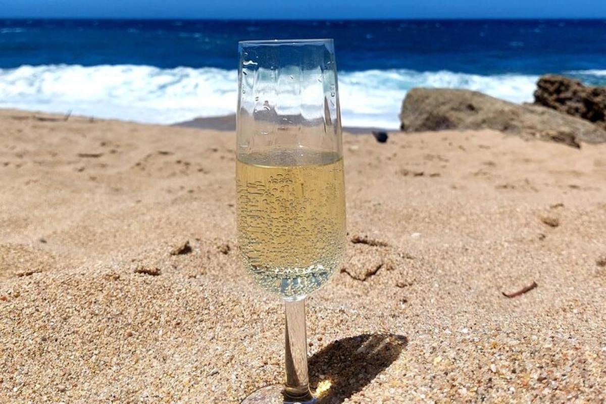 uma taça de champanhe na areia da praia