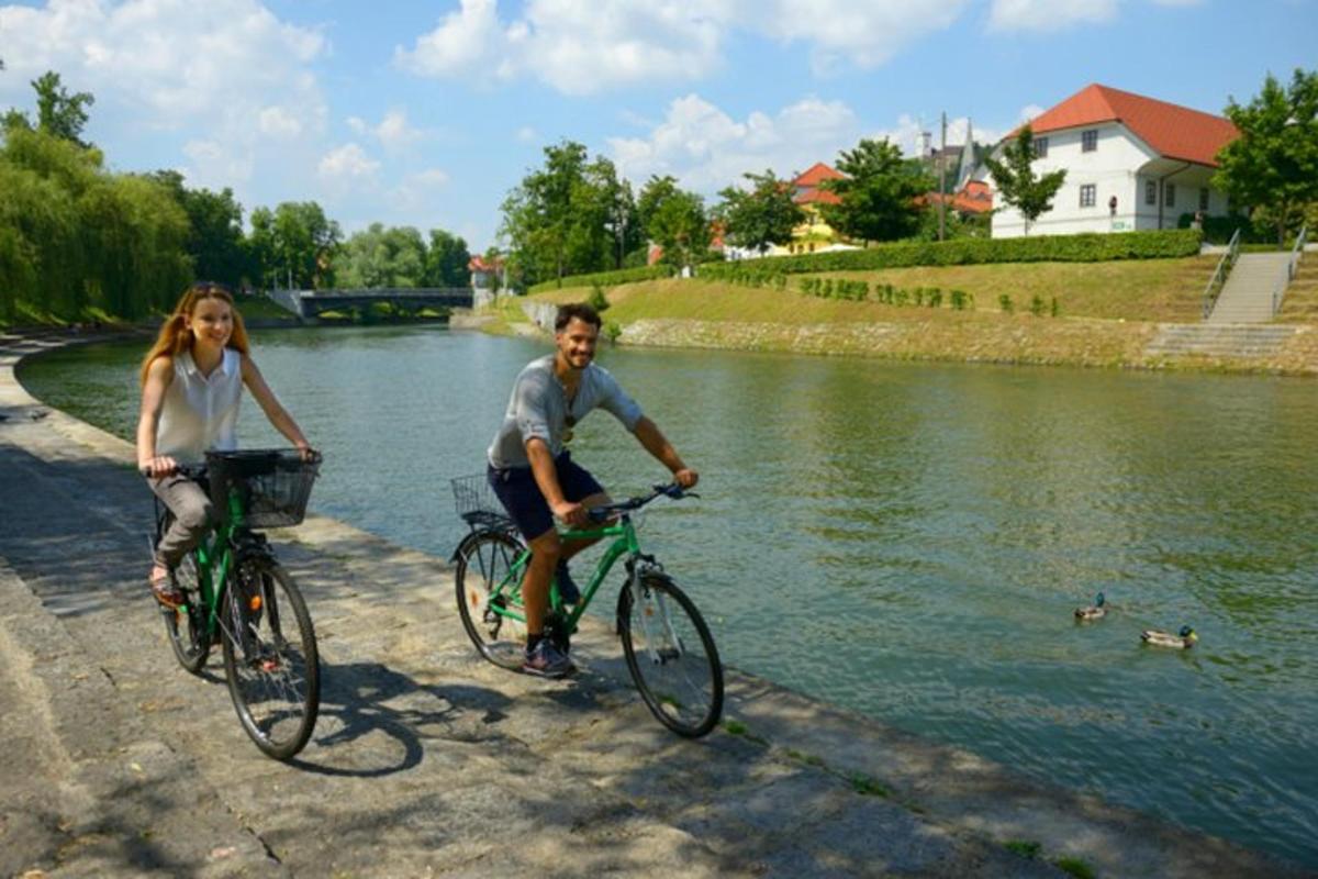 Ein Mann und eine Frau fahren Fahrrad neben einem Fluss