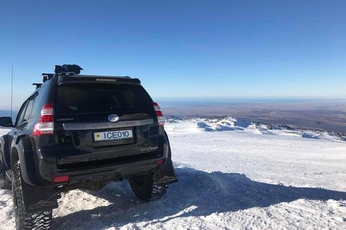 Svartur vörubíll lagður ofan á snæviþöktu fjalli