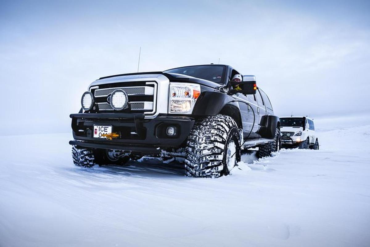 Un camión negro está estacionado en la nieve.