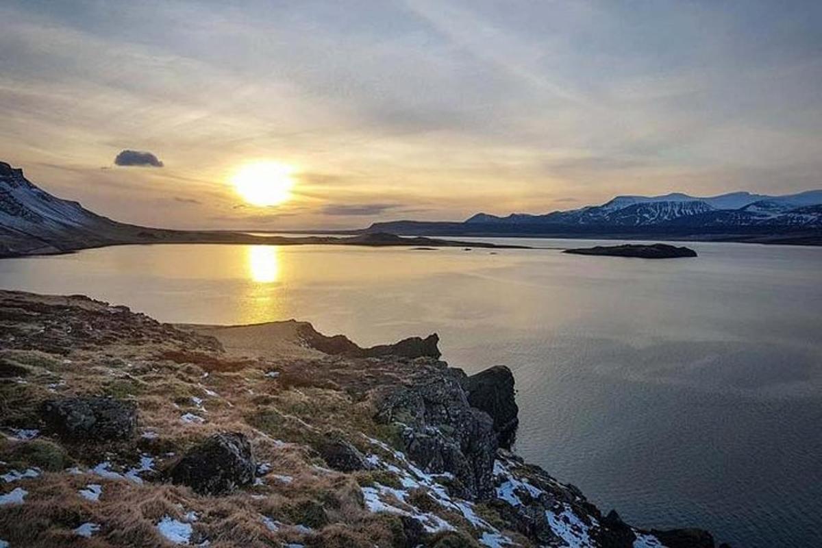 Sólarlag yfir vatn með fjöllum