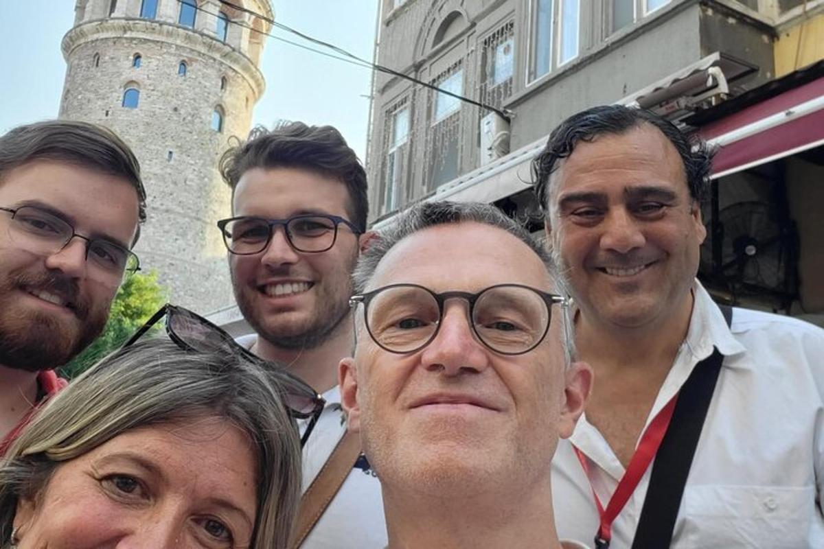 egy csoport ember pózol egy képhez egy kastély előtt