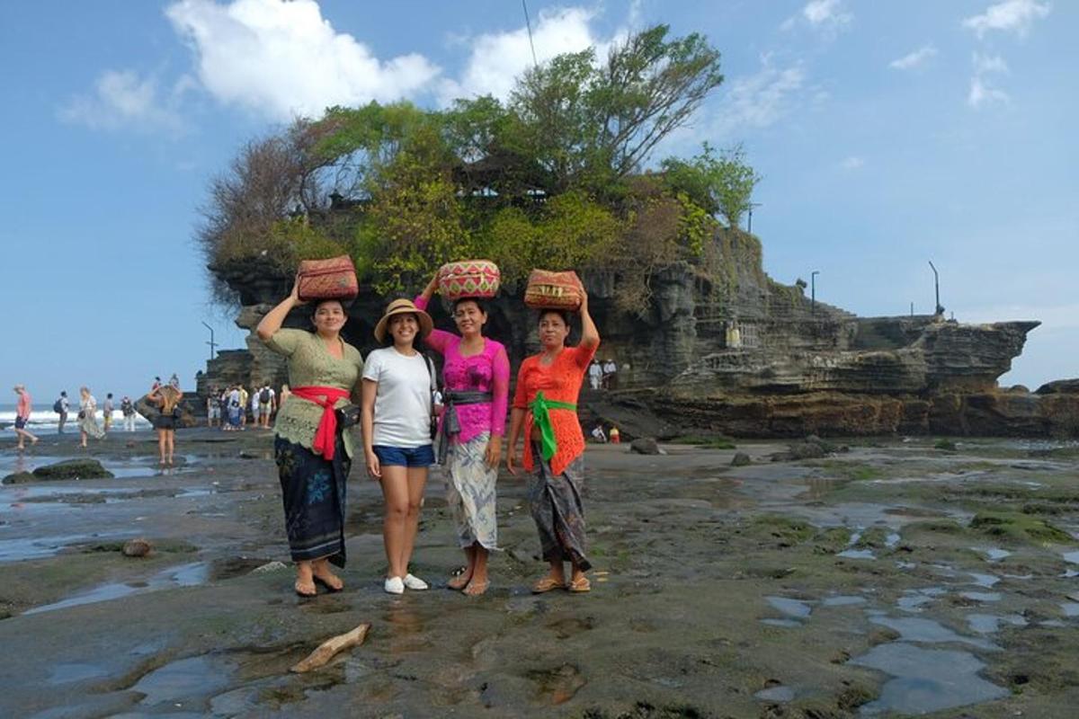 four women standing on a beach with baskets on their heads