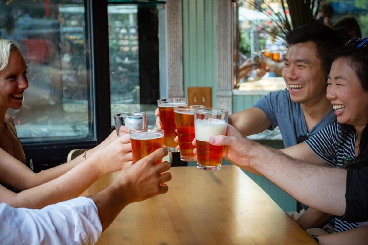 een groep mensen die rond een tafel zitten en bier drinken