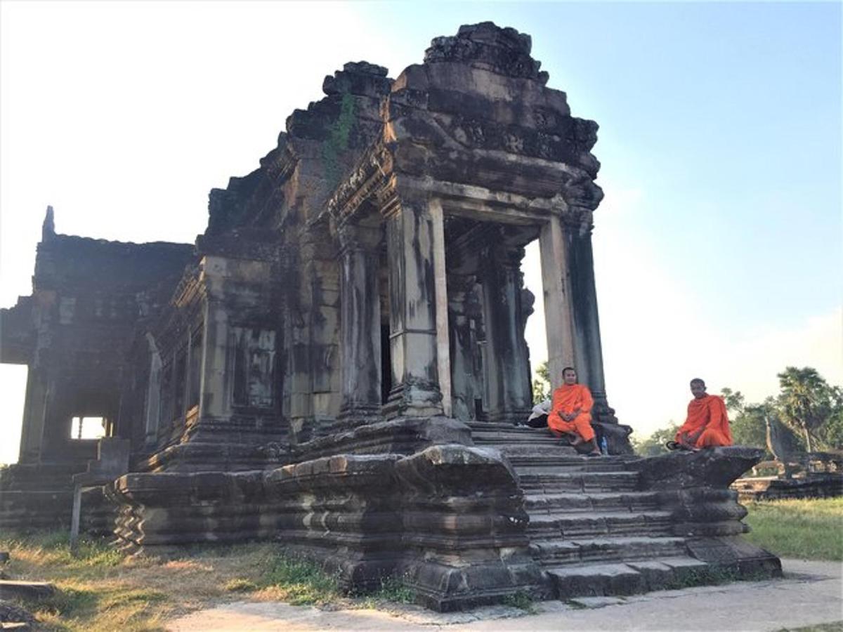 hai người đang ngồi trên đống đổ nát của một tòa nhà cũ
