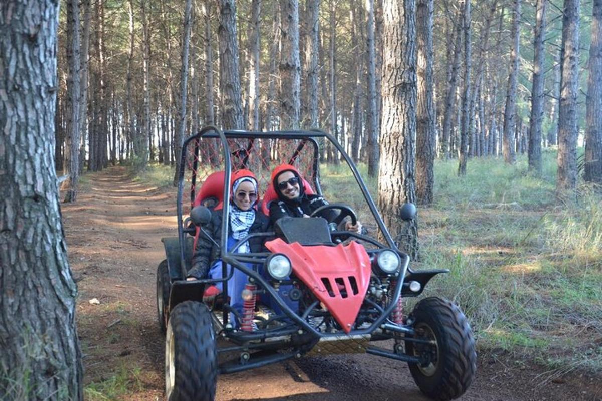 due persone a bordo di un quad nel bosco