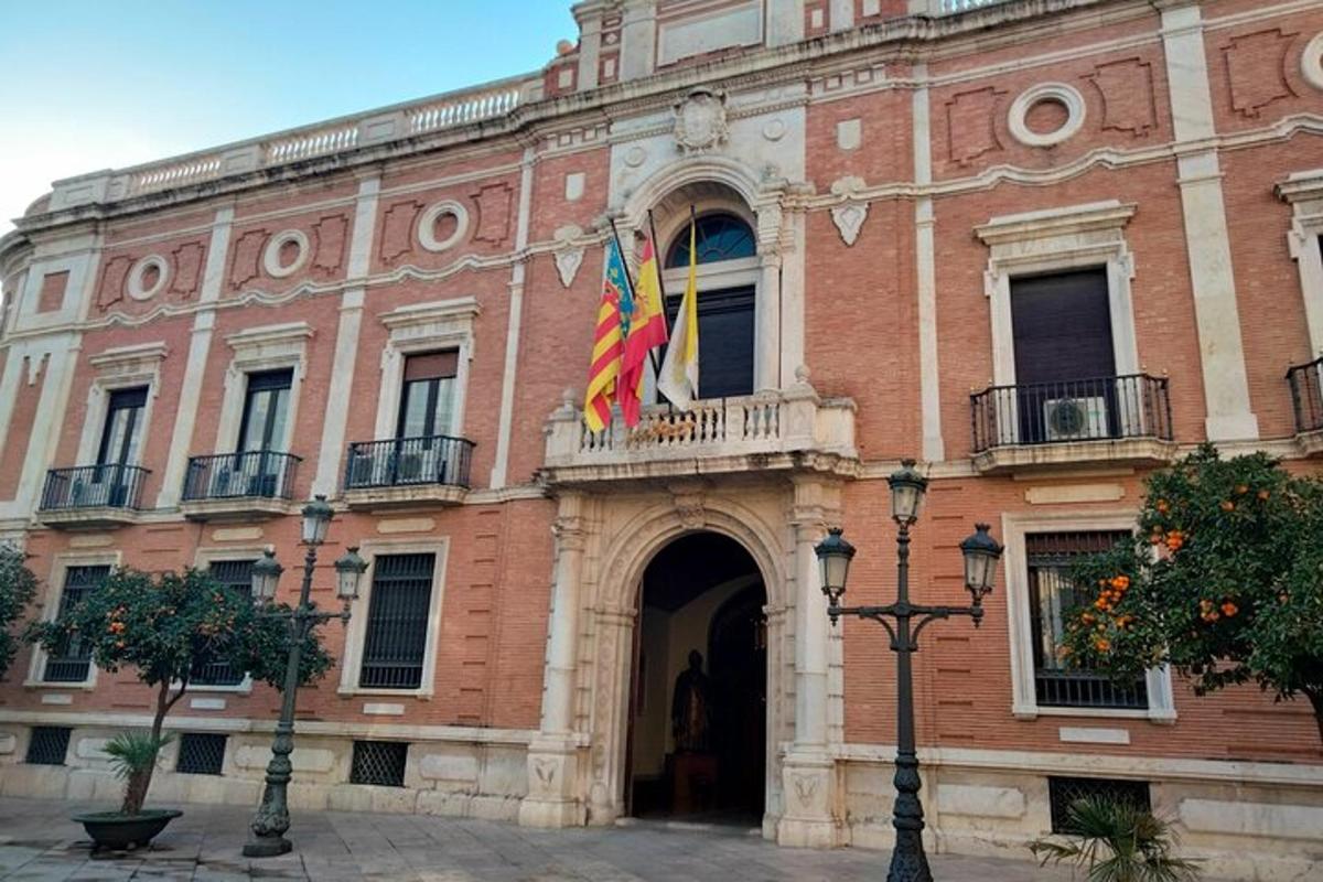 Un edificio con dos banderas delante.