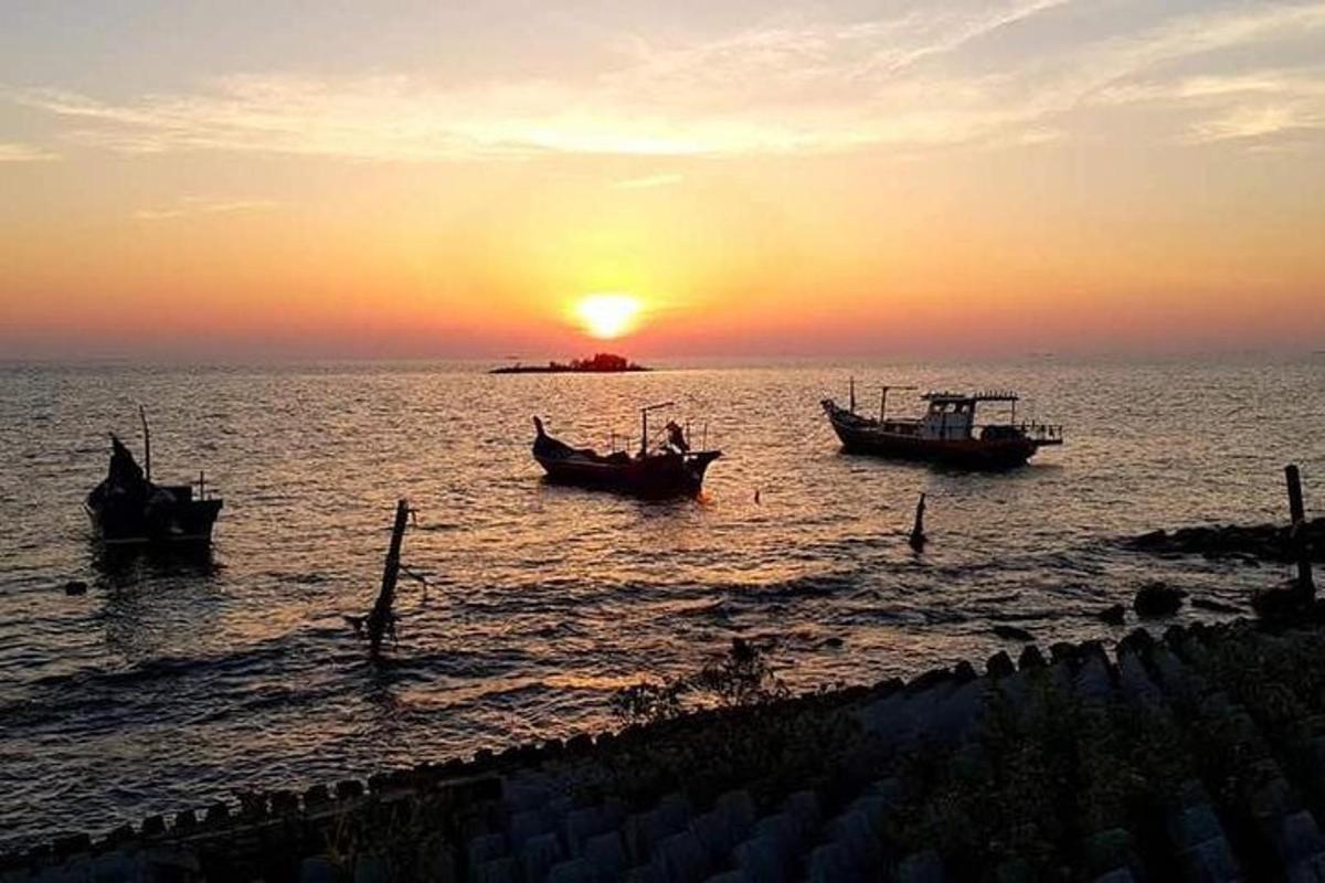 three boats in the water at sunset