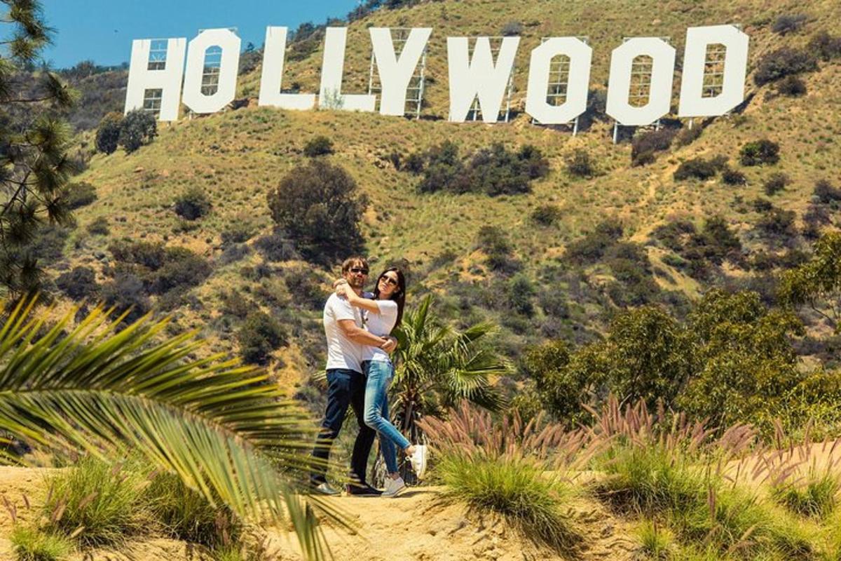ein Mann und eine Frau stehen vor dem Hollywood-Schild