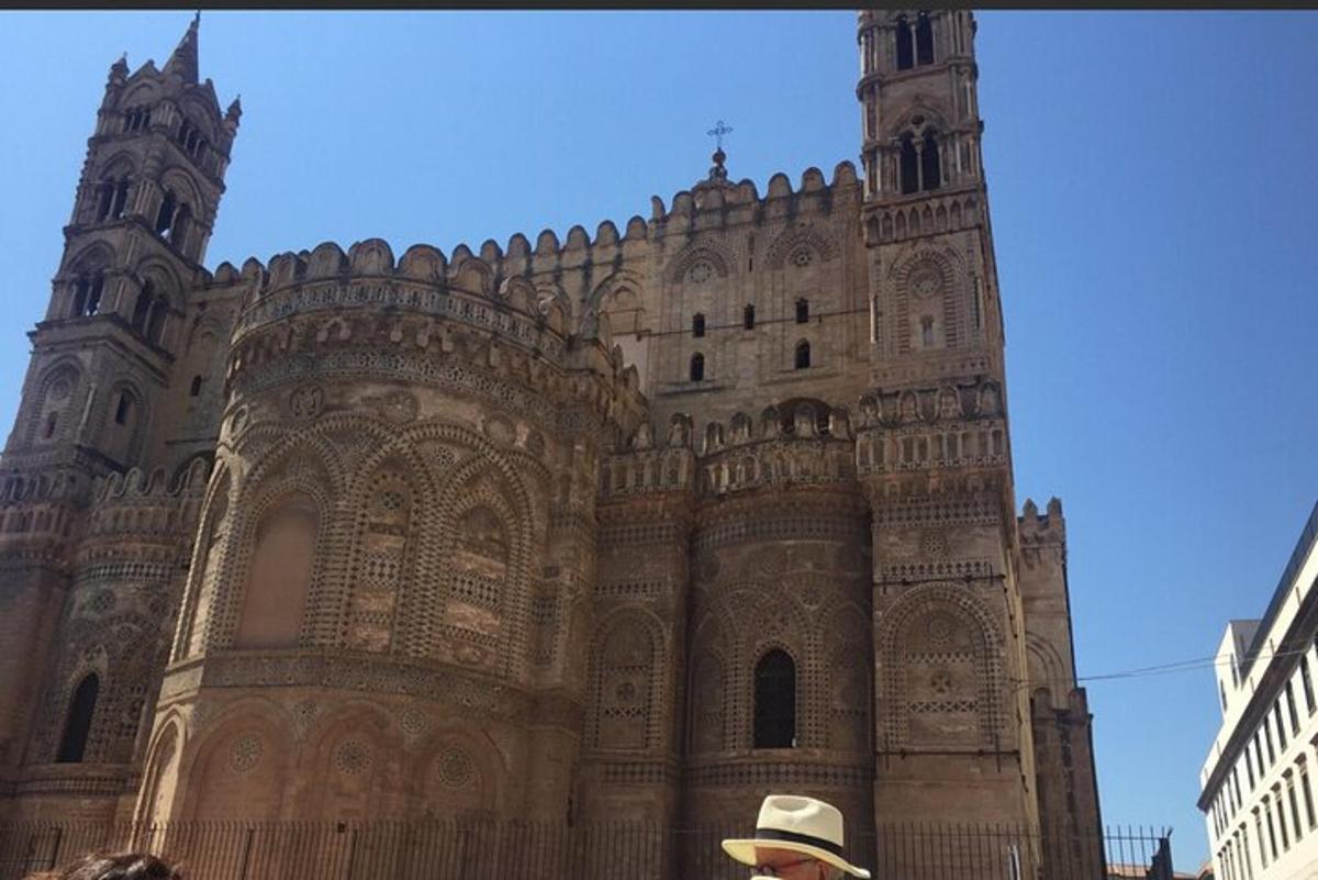 un uomo con un cappello in piedi davanti a un edificio
