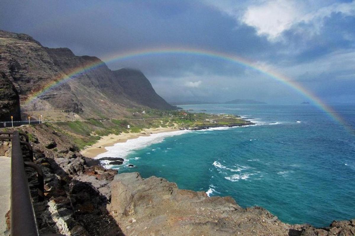 un arc-en-ciel sur l'océan et une plage avec un arc-en-ciel